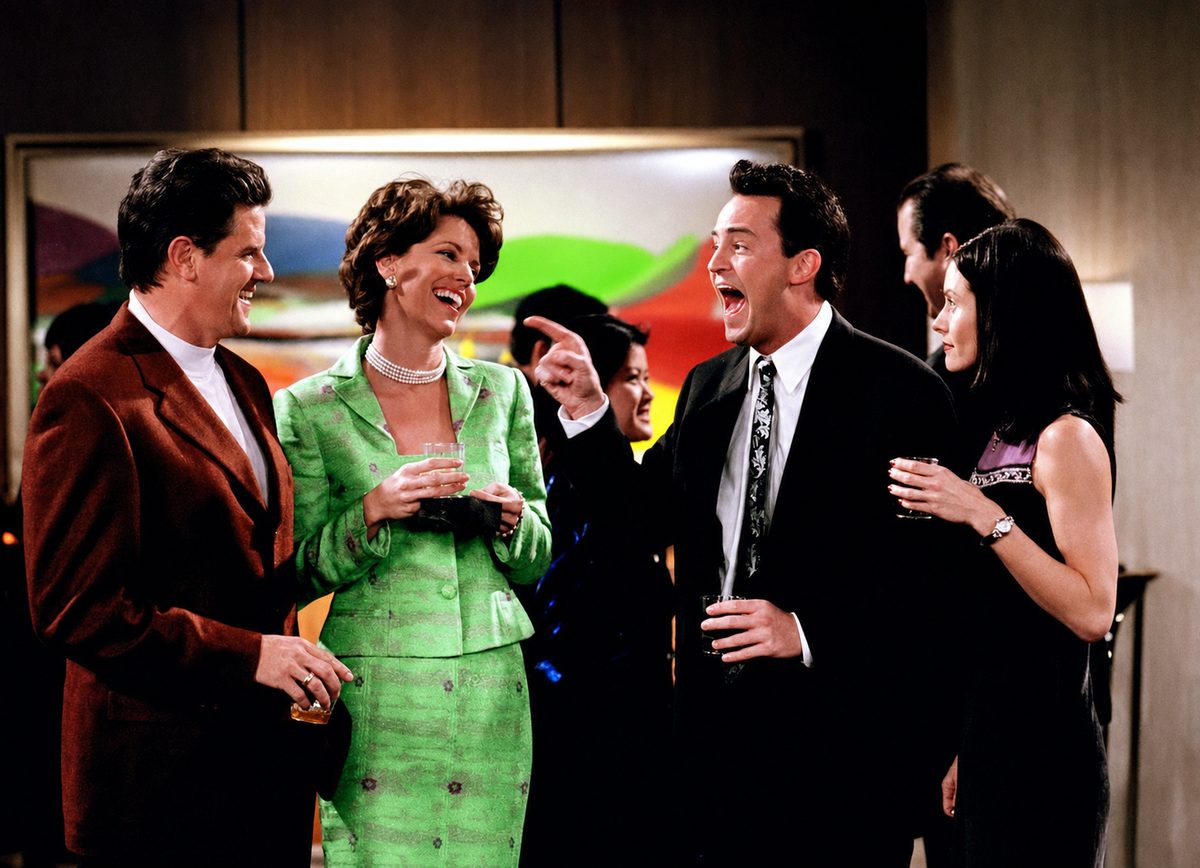 Sam McMurray laughing at a party in a scene from Friends.